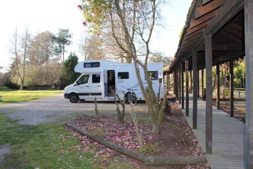 a white camper van parked next to a building at Rotorua Thermal Holiday Park in Rotorua