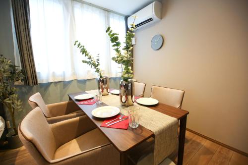 a dining room table with two chairs and a table at PrimeRoom別府 浜脇 in Beppu
