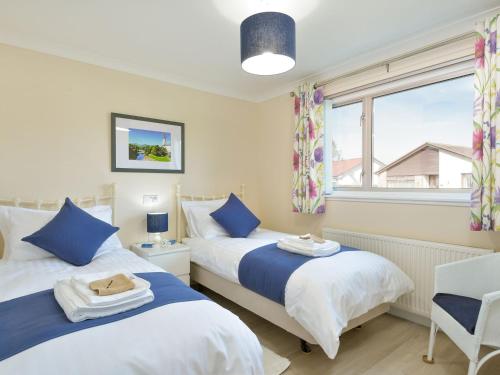 two beds in a small room with a window at Westburn in Comrie