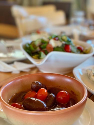 a bowl of food with tomatoes and a salad at Nassamat Boutique Hotel in Al Bārūk