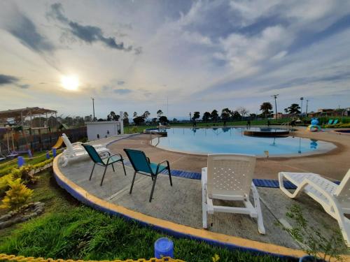 - un groupe de chaises assises autour d'une piscine dans l'établissement Apartamento privado a 2kms del parque del café, à Montenegro