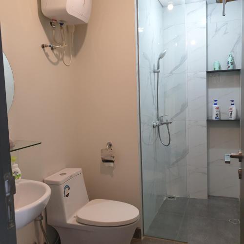 a bathroom with a toilet and a glass shower at CozyHomes at One Residence Batam in Batam Center