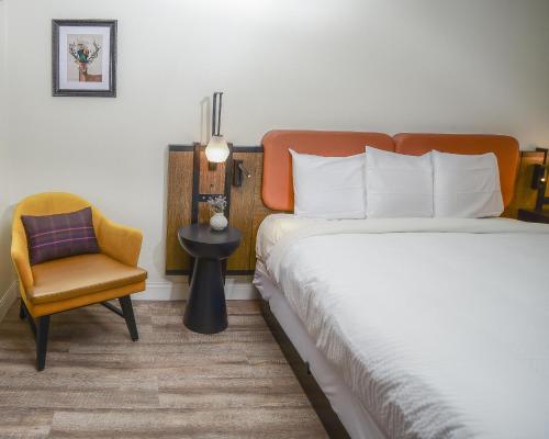 una camera d'albergo con letto e sedia di The Woodrose- NEWLY RENOVATED a Willits