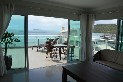 a living room with a view of the ocean at Belíssima cobertura duplex - De frente para o mar - Bombinhas-SC in Bombinhas