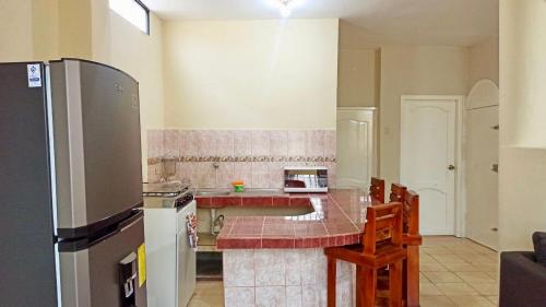eine Küche mit einer Arbeitsplatte und einem Kühlschrank in der Unterkunft Departamento la comodidad de tu casa in Machala