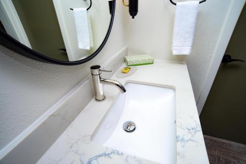 a bathroom with a white sink and a mirror at The Woodrose- NEWLY RENOVATED in Willits