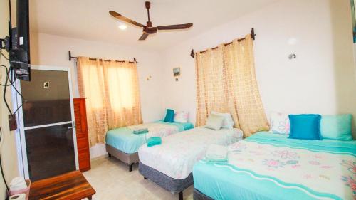 a bedroom with two beds and a ceiling fan at Siyan Ka'an Bak'halal in Bacalar