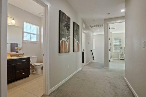a white bathroom with a toilet and a sink at Stunning River Islands Home Near Lake & Boat House in Lathrop