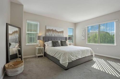 a bedroom with a large bed and two windows at Stunning River Islands Home Near Lake & Boat House in Lathrop