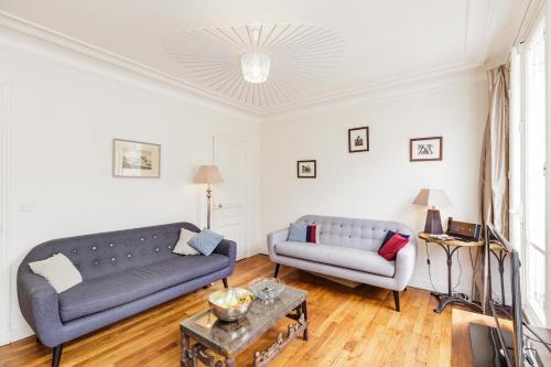 Sala de estar con 2 sofás y mesa en Large Apartment For A Family 2 Adults Max! en París