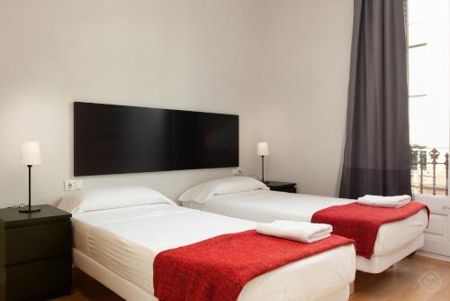 バルセロナにあるModern Center Apartmentsのベッド2台、薄型テレビが備わる客室です。