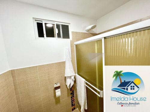 een badkamer met een douchecabine en een raam bij Imelda House in Ayangue