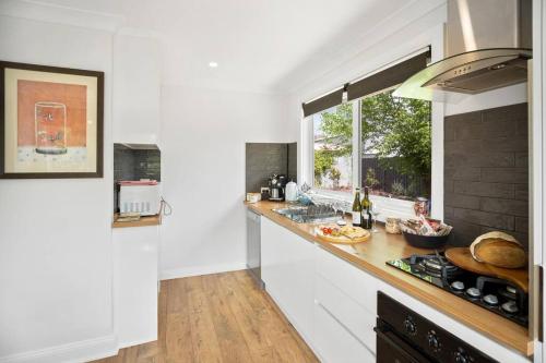 a kitchen with a counter with a sink and a window at Centrally located in the heart of the King Valley in Whitfield