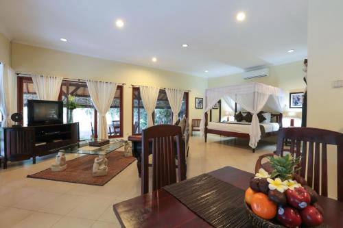 a living room with a dining table and a bedroom at Villa Coco Bali in Seminyak