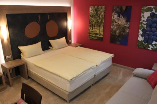 a bedroom with a large bed and a couch at Hotel-Gasthof Die Post Brennerei Frankenhöhe in Schillingsfürst