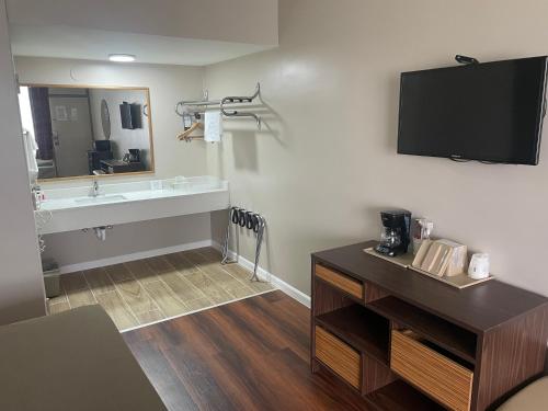 a bathroom with a sink and a large mirror at Super 8 by Wyndham Valdosta Mall in Valdosta