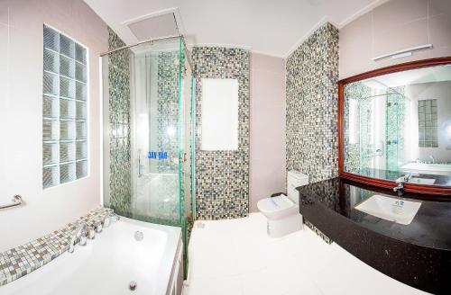y baño con bañera, lavamanos y ducha. en KHÁCH SẠN BẾN ĐÁ NÚI SAM en Chau Doc