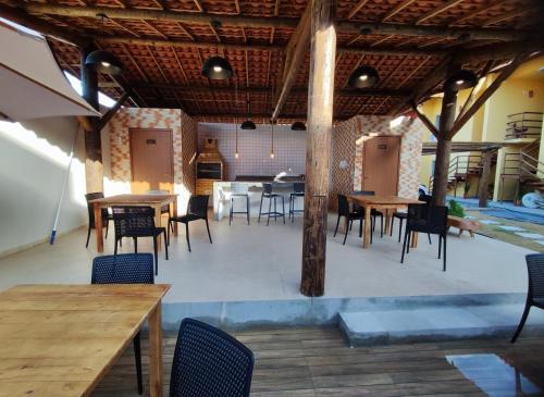 uma área de refeições com mesas e cadeiras num edifício em Casa na praia com piscina em Luís Correia