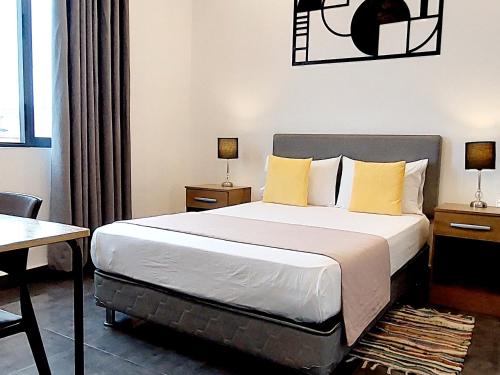 1 dormitorio con 1 cama grande con almohadas amarillas en Mandala en Pisco