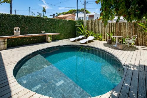 a swimming pool on a wooden deck with a table and chairs at Loft Trancoso com Piscina & Jacuzzi in Trancoso