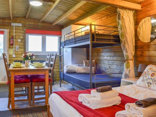 a bedroom with a bunk bed and a table and a desk at Robins Lodge in Westward