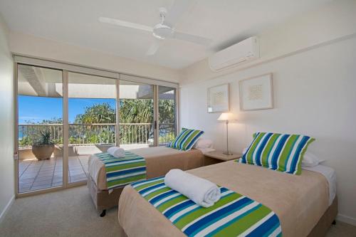 a hotel room with two beds and a balcony at Costa Nova Holiday Apartments in Sunshine Beach