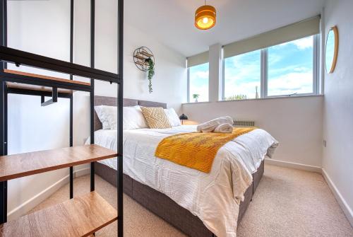 貝辛斯托克的住宿－Stylish 2 bed flat in Basingstoke By 20Property Stays Short Lets & Serviced Accommodation，一间卧室设有一张床和两个窗户。