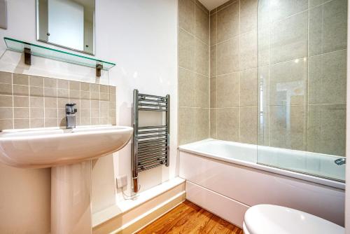 貝辛斯托克的住宿－Stylish 2 bed flat in Basingstoke By 20Property Stays Short Lets & Serviced Accommodation，浴室配有盥洗盆、卫生间和浴缸。