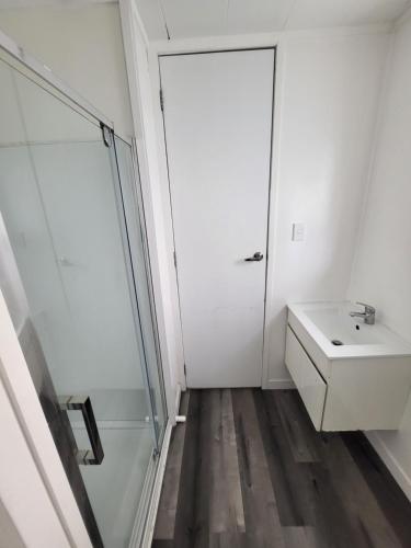 a white bathroom with a sink and a shower at Rockfield Motel in Auckland