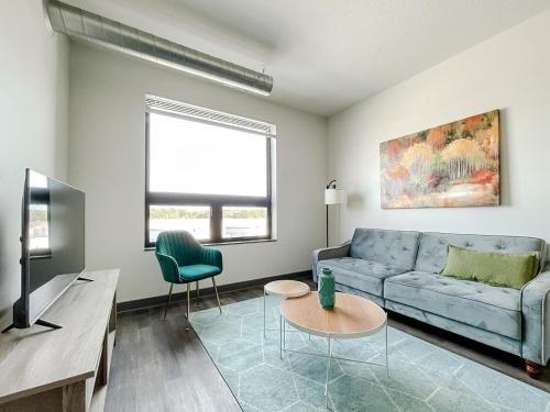a living room with a blue couch and a tv at Sleepover 1BD 1BA Des Moines Apartments in Des Moines