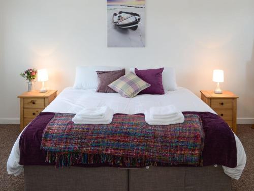 a bedroom with a large bed with two night stands at Beach Cottage in Nairn