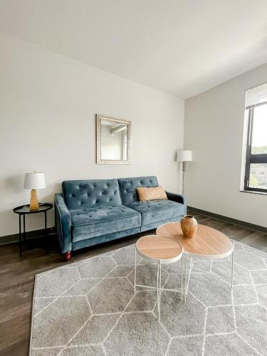 a living room with a blue couch and a table at Sleepover 1BD 1BA Des Moines Apartments in Des Moines