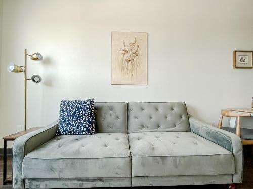 a couch sitting in a living room next to a wall at Sleepover 1BD 1BA Des Moines Apartments in Des Moines
