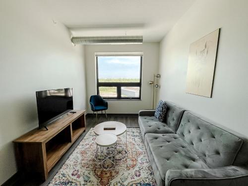a living room with a couch and a television at Sleepover 1BD 1BA Des Moines Apartments in Des Moines