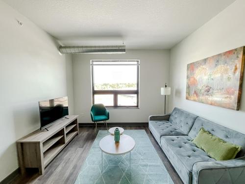 a living room with a couch and a tv at Sleepover 1BD 1BA Des Moines Apartments in Des Moines