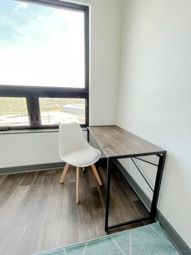 a white chair sitting next to a glass desk at Sleepover 1BD 1BA Des Moines Apartments in Des Moines