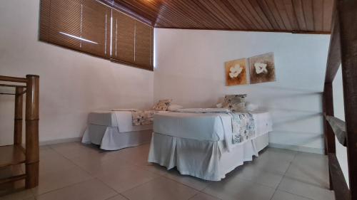 two tables in a room with white walls at Pousada Sol e Mar in Juquei