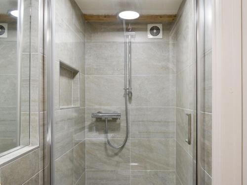 a shower with a glass door in a bathroom at Easter Cottage in Bamford