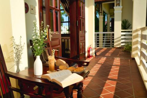 a table with an open book and bread on it at The Muse House in Hoi An