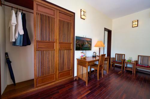 a room with a desk and a wooden door at The Muse House in Hoi An