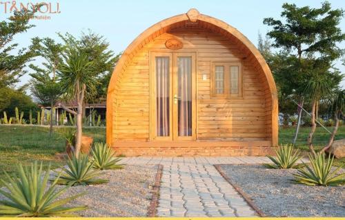una piccola cabina in legno con una porta in giardino di Tanyoli Resort a Phan Rang-Tháp Chàm