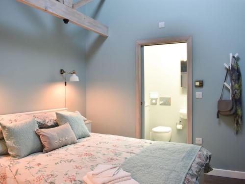 a bedroom with a bed with pink and blue walls at Primrose in Scruton
