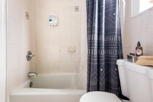 a bathroom with a toilet and a shower curtain at The Cozy Villa-private parking in Miami