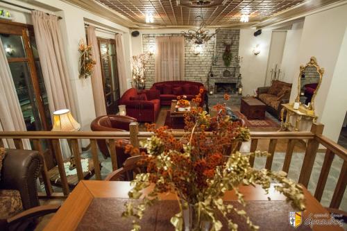 a living room with a table with flowers on it at Arkefthos Mountain Hotel in Papigko