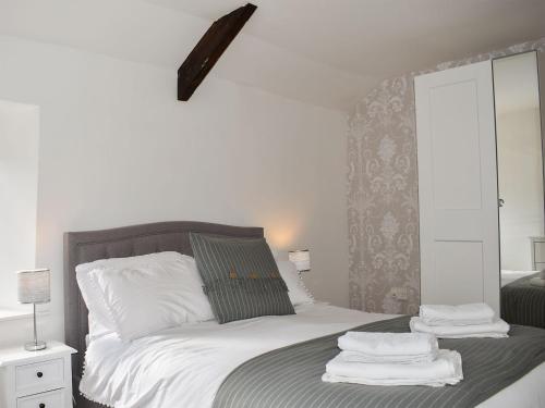 a bedroom with a bed with towels on it at Lavender Cottage in Leyburn