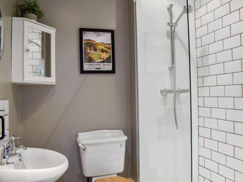 uma casa de banho com um WC, um lavatório e um chuveiro em Lavender Cottage em Leyburn