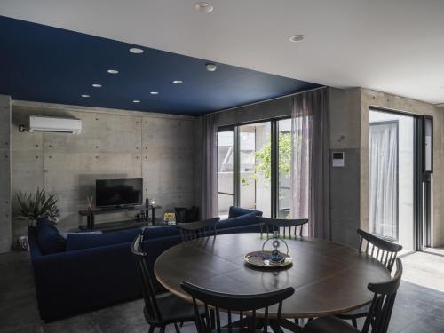 a living room with a table and a blue couch at La luna in Yomitan