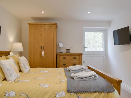 a bedroom with a bed with towels on it at Ladyvale Barn in Cardinham