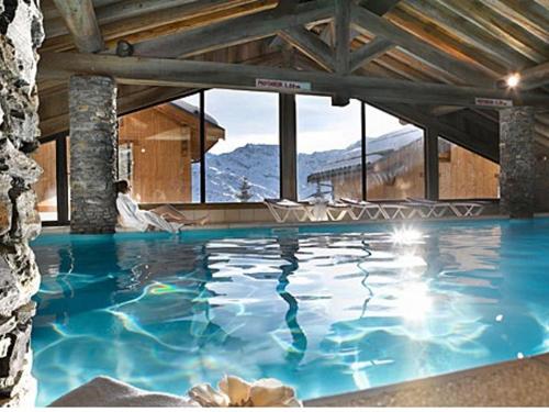 - une grande piscine dans un bâtiment doté de fenêtres dans l'établissement Appartement 3P avec Balcon, Piscine et Parking · Proche Pistes à Reberty 2000 - FR-1-344-741, aux Menuires