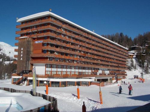 un grand bâtiment sur une piste de ski dans la neige dans l'établissement Studio fonctionnel avec balcon, accès direct aux pistes - Plagne Centre - FR-1-181-2653, à La Plagne Tarentaise